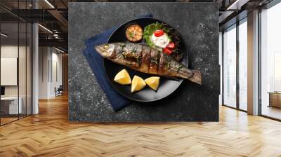 Plate with delicious sea bass fish and ingredients on dark grey table, top view Wall mural