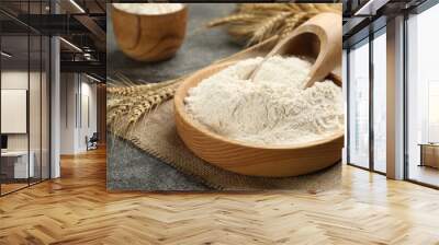 Plate with wheat flour and wooden scoop on grey table Wall mural