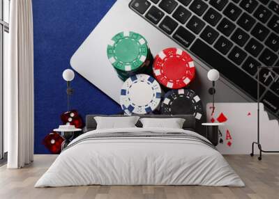 Poker chips, laptop, playing cards and dices on blue table, flat lay. Online game Wall mural