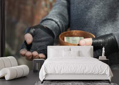 Poor homeless man holding bowl with donations outdoors, closeup Wall mural