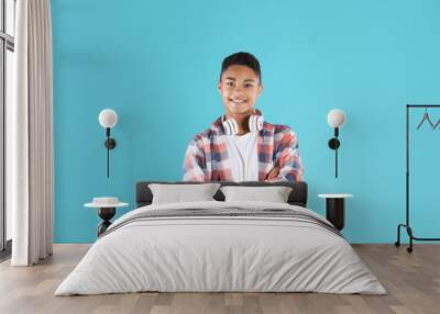 Portrait of African-American teenage boy with headphones on color background Wall mural