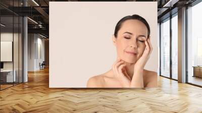 Portrait of beautiful mature woman on beige background. Space for text Wall mural