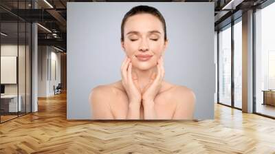 Portrait of beautiful young woman with perfect skin on grey background. Spa treatment Wall mural