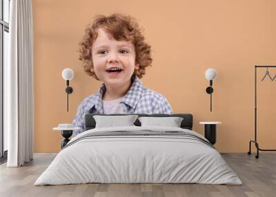 Portrait of cute little boy on beige background, space for text Wall mural