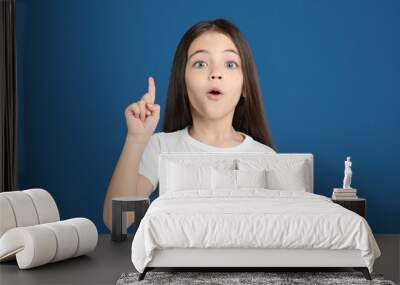 Portrait of cute little girl on blue background Wall mural