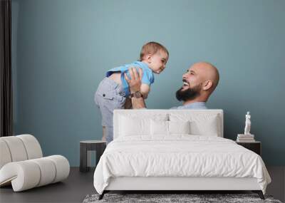 Portrait of dad and his little son on color background Wall mural