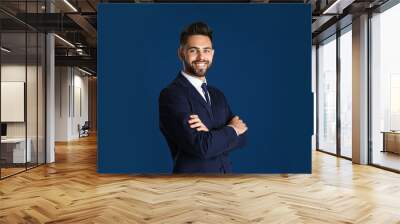 Portrait of handsome smiling man in office suit on color background Wall mural