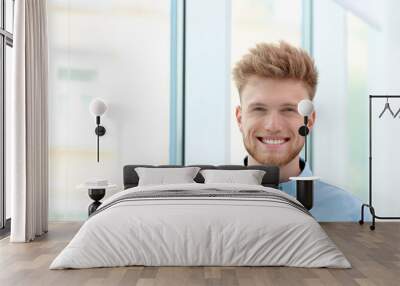 Portrait of handsome young man near window Wall mural