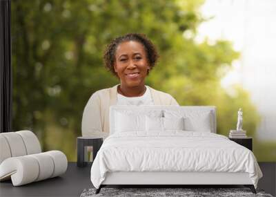 Portrait of happy African-American woman in park Wall mural