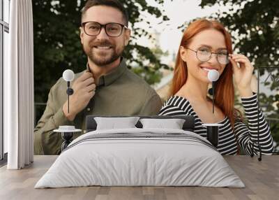 Portrait of happy couple in glasses outdoors Wall mural