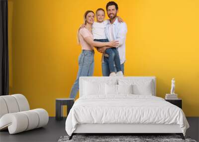 Portrait of happy family on orange background Wall mural