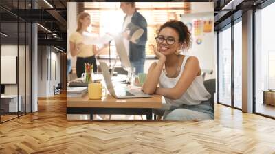 Portrait of happy female designer in office Wall mural