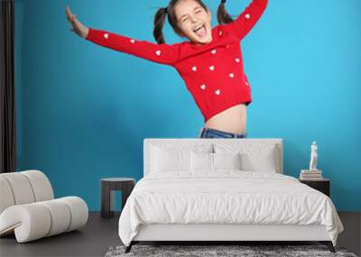 Portrait of little girl jumping on color background Wall mural