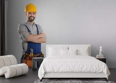 Portrait of professional construction worker with tool belt on grey background, space for text Wall mural