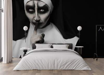 Portrait of scary devilish nun on black background, space for text. Halloween party look Wall mural