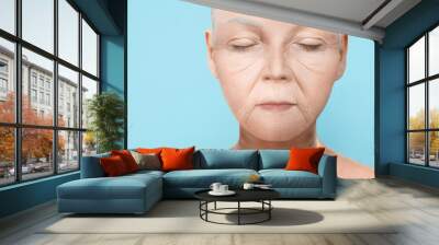 Portrait of senior woman on light blue background Wall mural