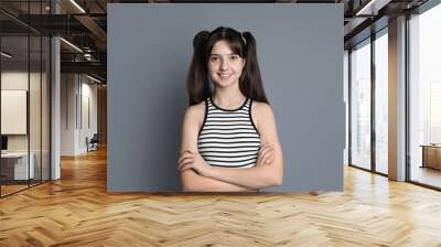 Portrait of smiling teenage girl on grey background Wall mural