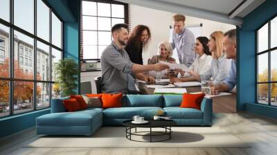 Portrait of volunteers having meeting in office Wall mural