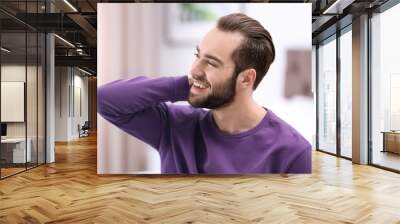 Portrait of young man with beautiful hair indoors Wall mural