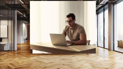 Portrait of young man with laptop at table indoors Wall mural