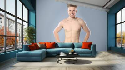 Portrait of young man with slim body in towel on grey background. Space for text Wall mural