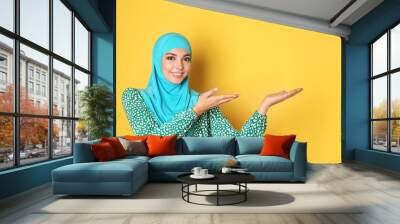 Portrait of young Muslim woman in hijab against color background. Space for text Wall mural