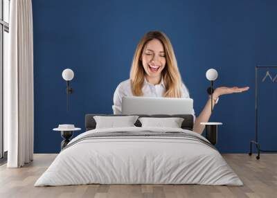 Portrait of young woman in office wear with laptop on color background Wall mural