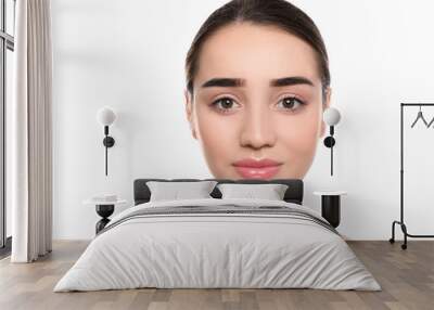 Portrait of young woman with beautiful face against white background Wall mural