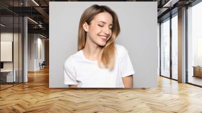 Portrait of young woman with beautiful face on grey background Wall mural