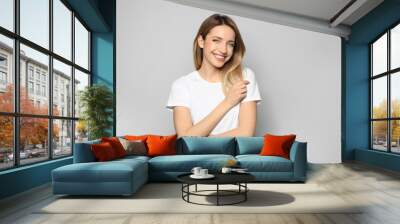 Portrait of young woman with beautiful face on grey background Wall mural