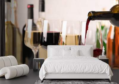 Pouring red wine from bottle into glass, closeup Wall mural