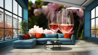 pouring rose wine into glass in garden, closeup Wall mural