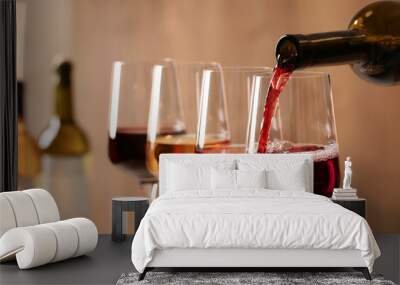 Pouring wine from bottle into glass on blurred background, closeup Wall mural