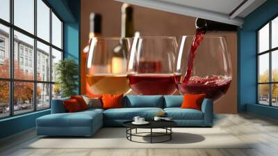 Pouring wine from bottle into glass on blurred background, closeup Wall mural