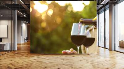 Pouring wine from bottle into glass outdoors, space for text Wall mural