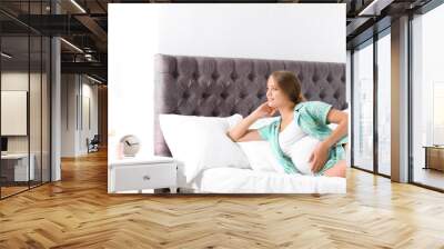 Pregnant woman lying in bed at home Wall mural