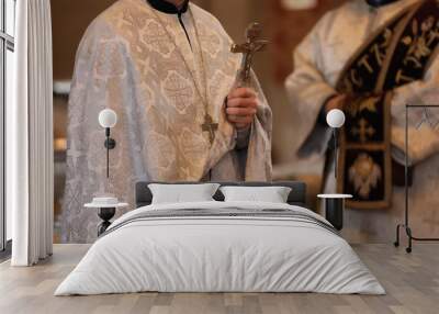 Priest with cross conducting baptism ceremony in church, closeup Wall mural