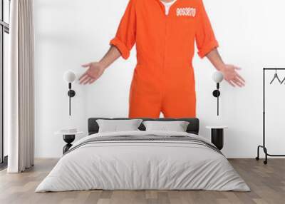 Prisoner in jumpsuit with metal ball perplexedly shrugging his shoulders on white background Wall mural