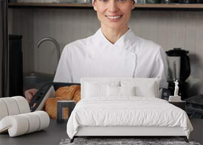 Professional baker with freshly baked croissants in store Wall mural