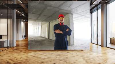 Professional builder in safety equipment at construction site Wall mural