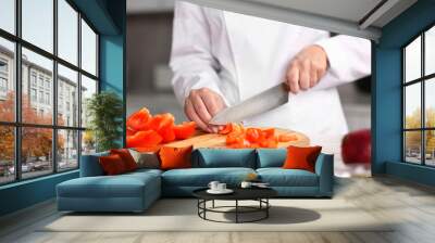 Professional chef cutting pepper at table in kitchen, closeup Wall mural