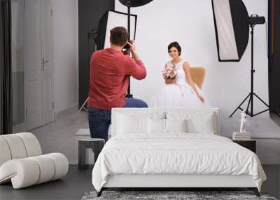 Professional photographer taking photo of beautiful bride in studio Wall mural