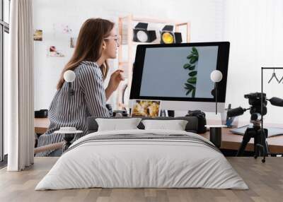 Professional photographer working at table in office Wall mural