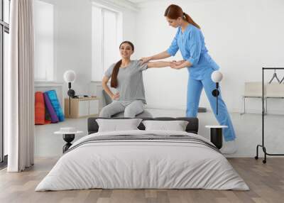 Professional physiotherapist working with female patient in rehabilitation center Wall mural