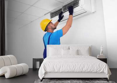 Professional technician maintaining modern air conditioner indoors Wall mural