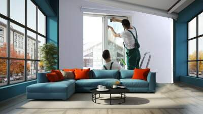 Professional workers tinting window with foil indoors Wall mural