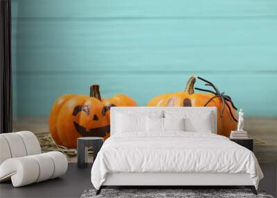 Pumpkins with scary faces on light blue wooden background, space for text. Halloween decor Wall mural