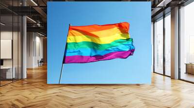 Rainbow LGBT flag fluttering on blue sky background. Gay rights movement Wall mural