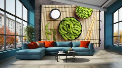 Raw green edamame soybeans and pods on grey table, top view Wall mural