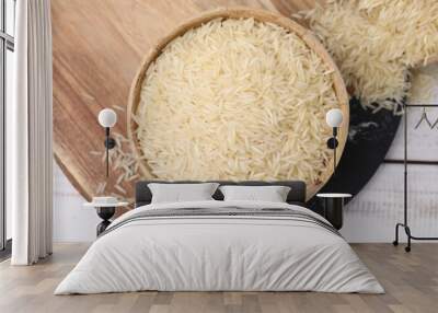 Raw rice in bowl on light wooden table, top view Wall mural